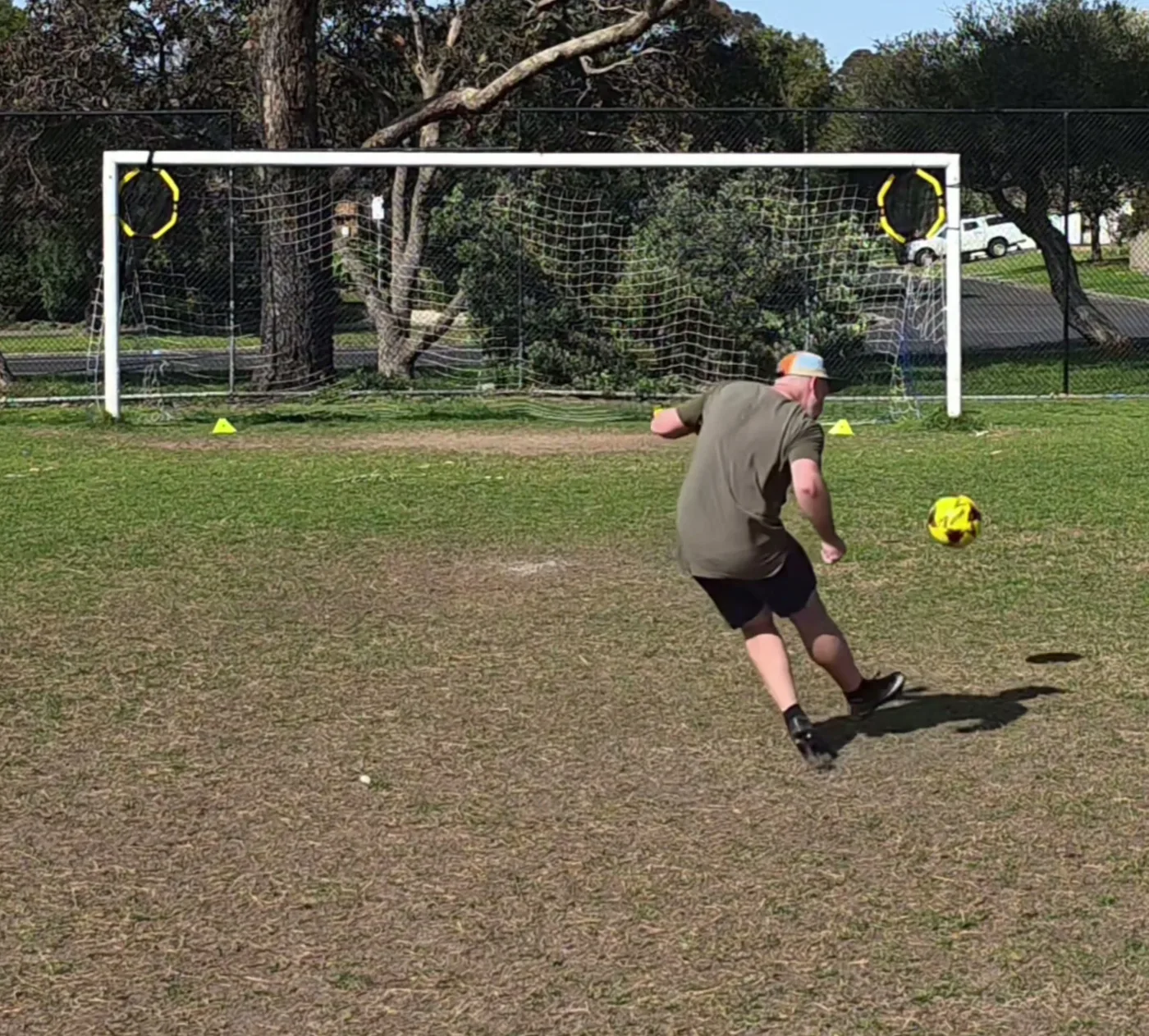 Liam demonstrating a shot at goal on a training pitch